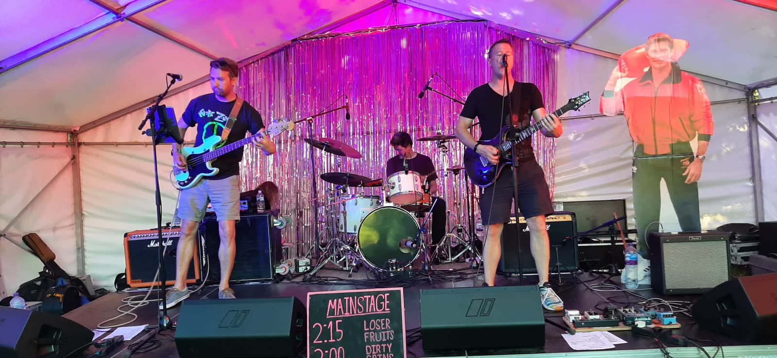 A band playing on the Hoodstock stage with a crowd in front