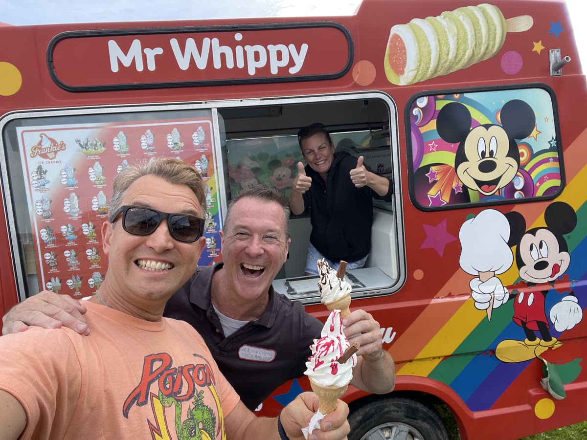 Friends smiling beside an ice cream van