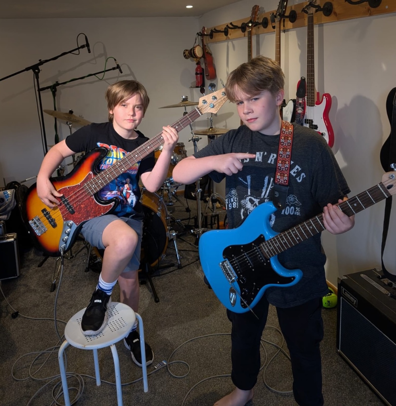 Two young Digital Deckhands holding guitars in a rehearsal room