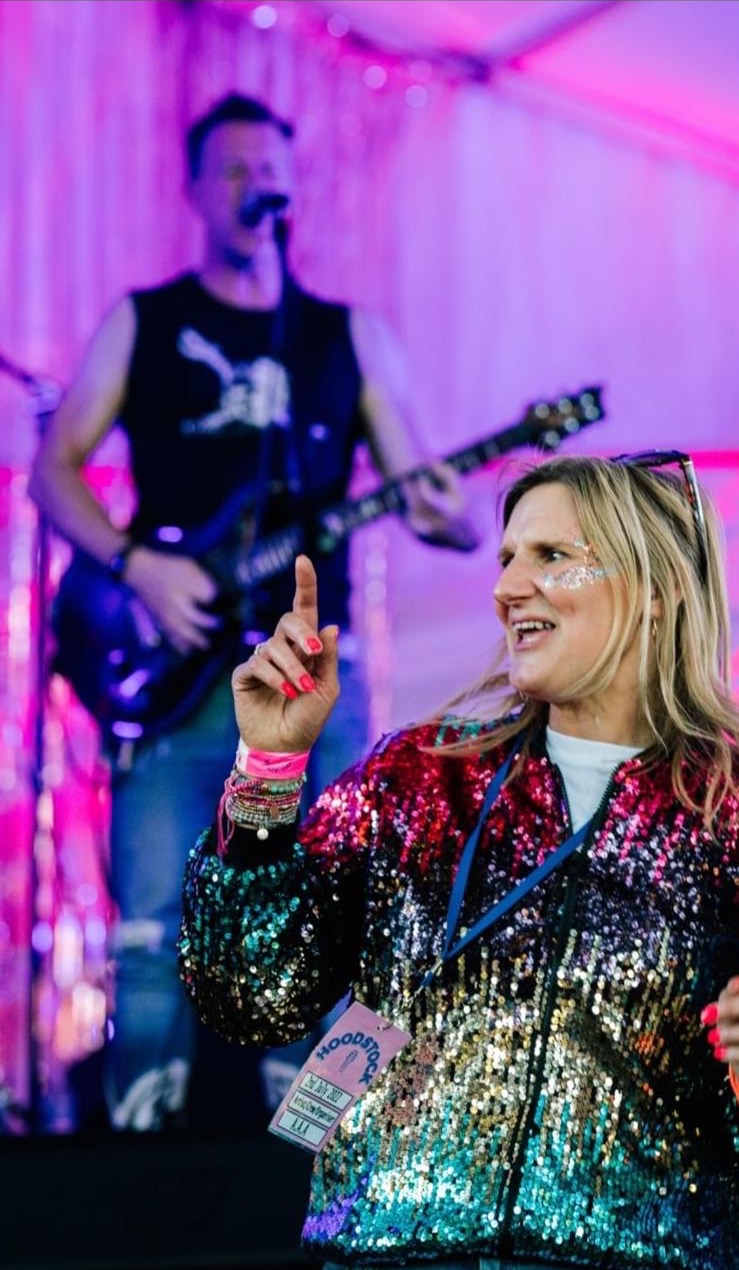 Suzie Butler in front of a blurred stage performance